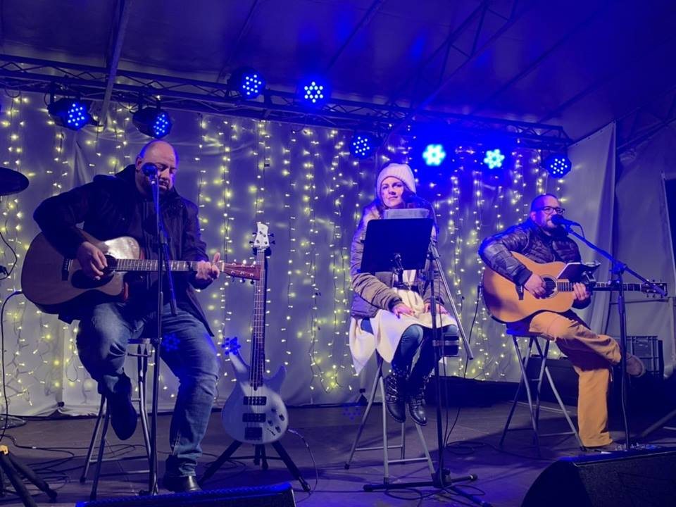 Coffee Shop Acoustic na večernjem nastupu s plavim i ljubičastim svjetlima.